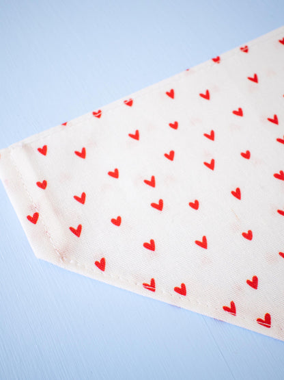 White fabric with red heart patterns on a light blue background