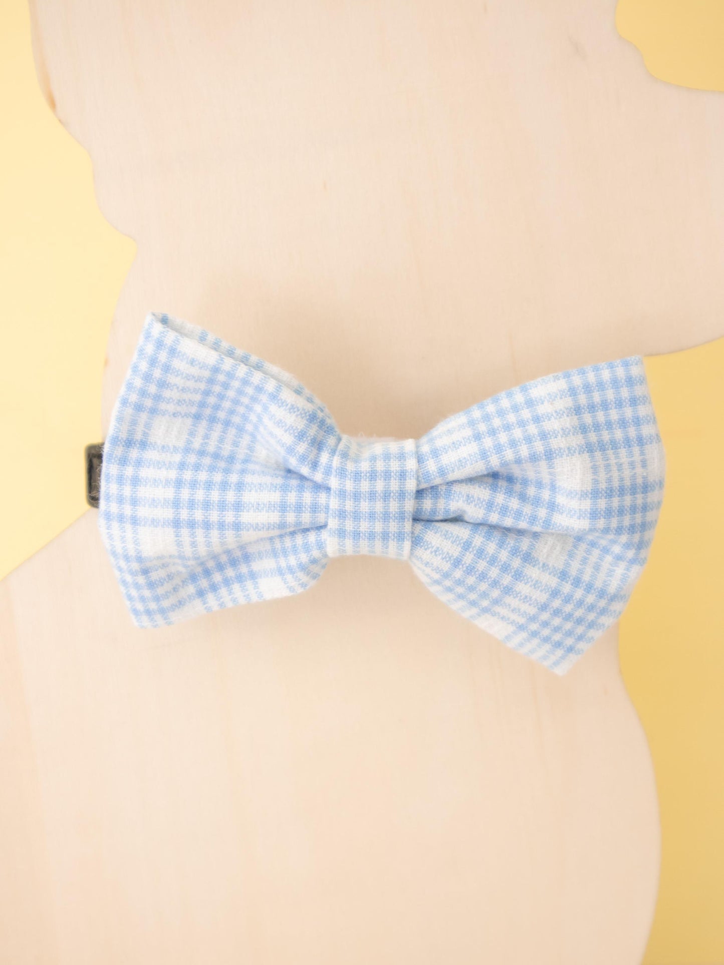 Blue checkered bow tie on a beige background