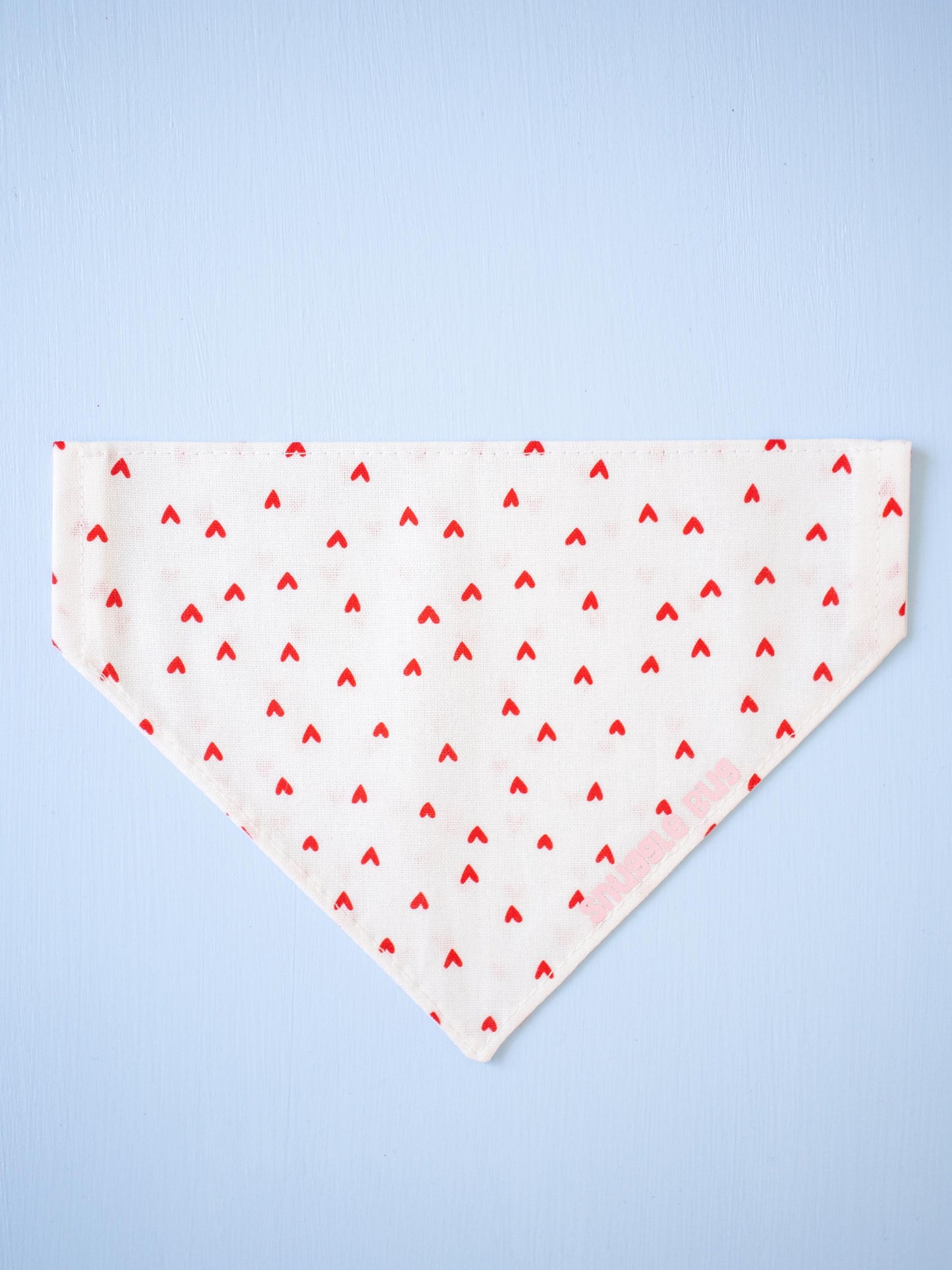 White bandana with red heart pattern on a light blue background