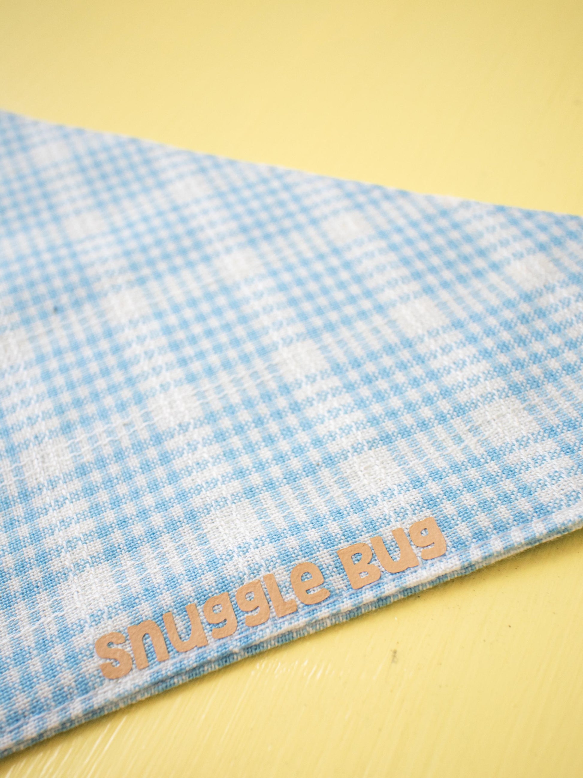 Blue checkered blanket with 'Snuggle Bug' text on a yellow background