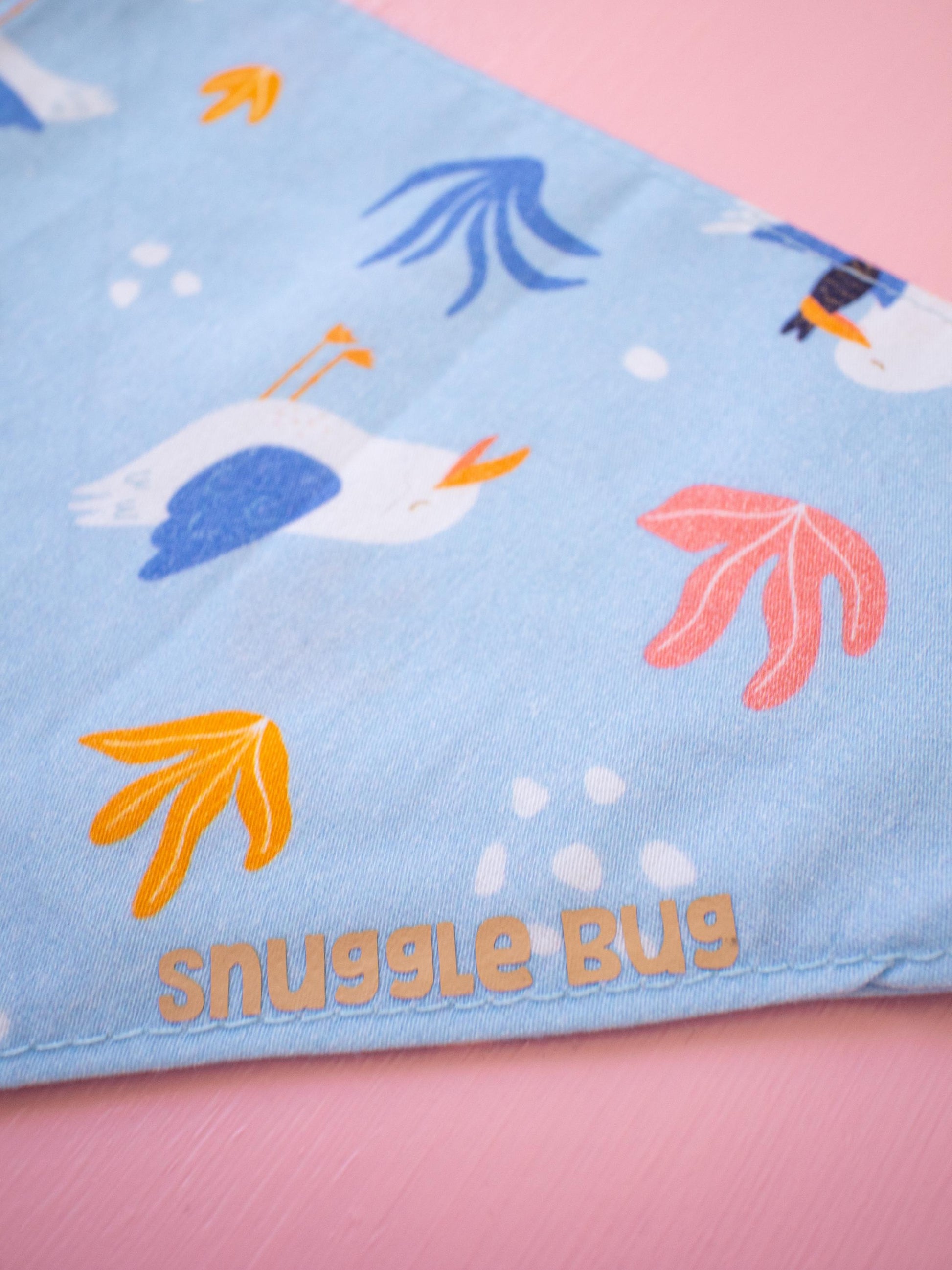 Dog Bandana with cartoon seagulls and 'snuggle bug' text on a pink background